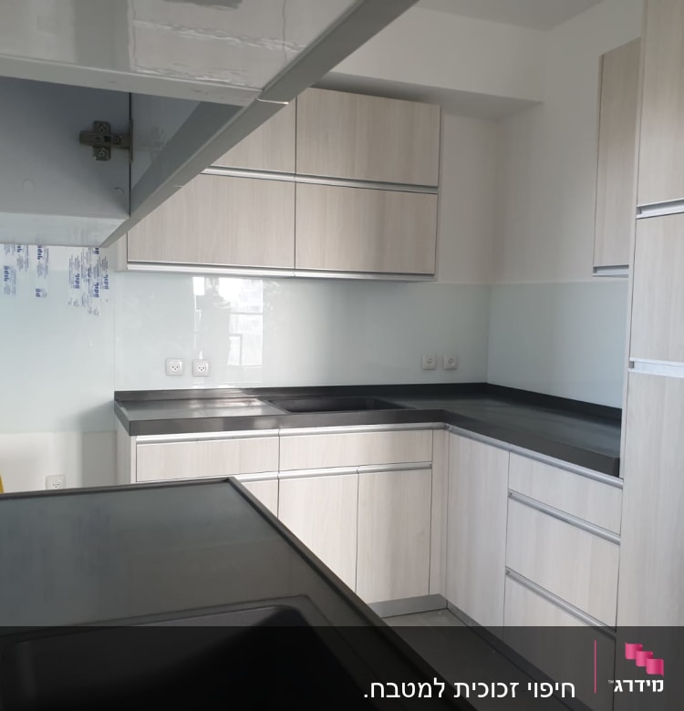 קיר זכוכית במטבח עם ארונות עץ